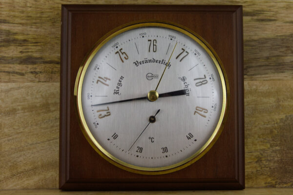 Barometer/ Thermometer auf dunklem Holz